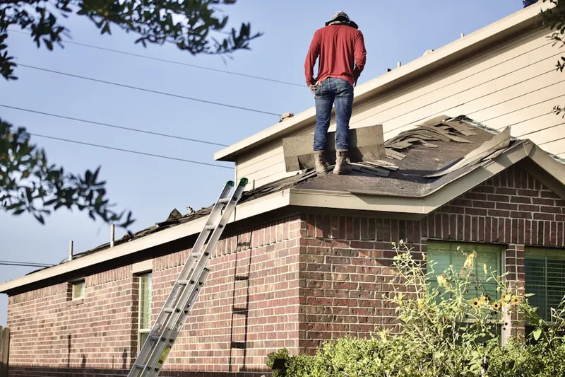 Professional roofer working on a residential roof in Almena